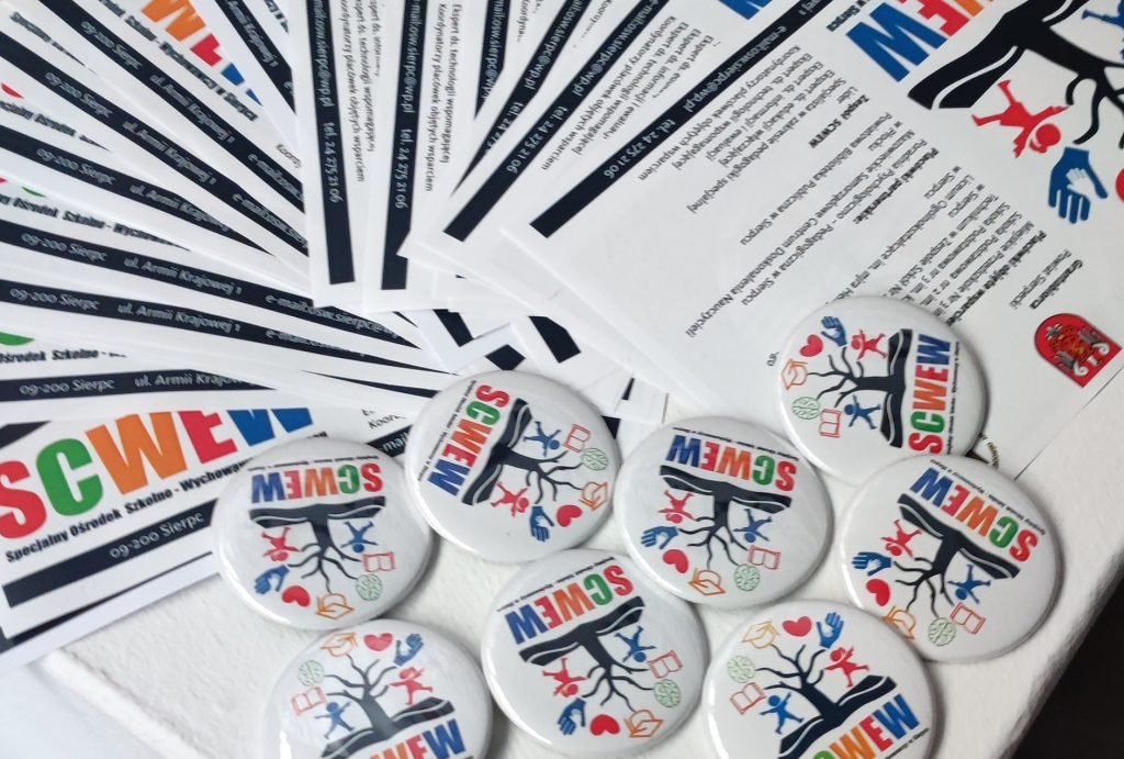 Zdjęcie przedstawia ulotki i znaczki reklamowe z napisem SCWEW
