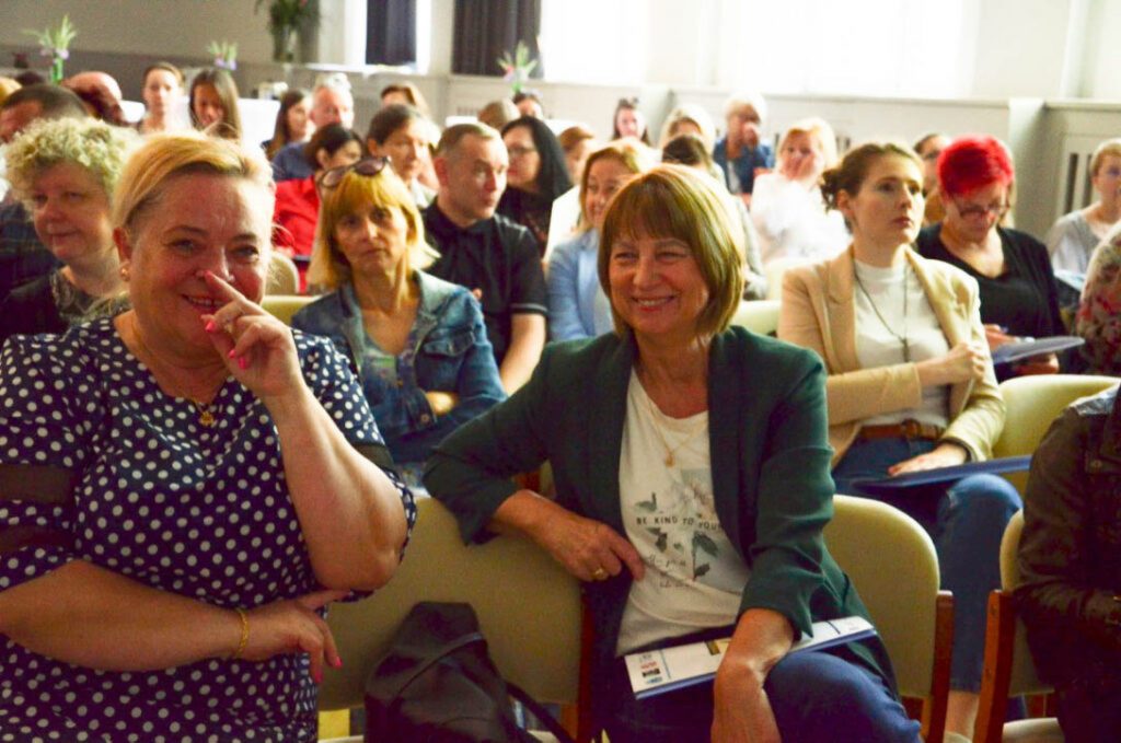 Zdjęcie przedstawia roześmianych uczestników konferencji