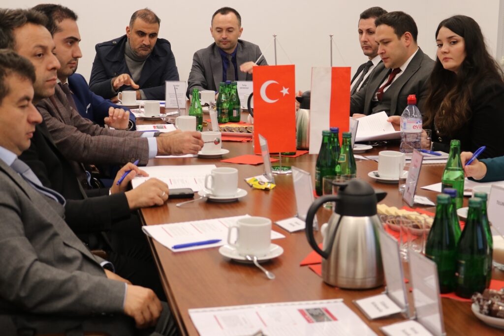 od lewej (nie uwzględnia tłumaczy): Hakan Baral ekspert ds. migracji; Mustafa Güney ekspert ds. migracji; Yusuf Kaya, urzędnik państwowy; Serdar Dal Zastępca Dyrektora Regionalnej Dyrekcji Zarządzania Migracją w Stambule; Talip Menekşe kierownik działu (szef delegacji); Gürkan Güngöroğlu ekspert ds. migracji; Ufkum Kemal Edisan ekspert ds. migracji; Esranur Sümer ekspertka ds. migracji