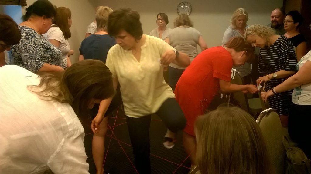 Sieć współpracy instytucji w zakresie doradztwa utworzona z krzesełek z nazwami instytucji, karteczek z opisem zakresu usług i włóczki