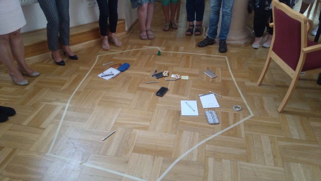 Przedmioty wizualizujące potrzeby uczestników spotkania na zarysie mapy Polski