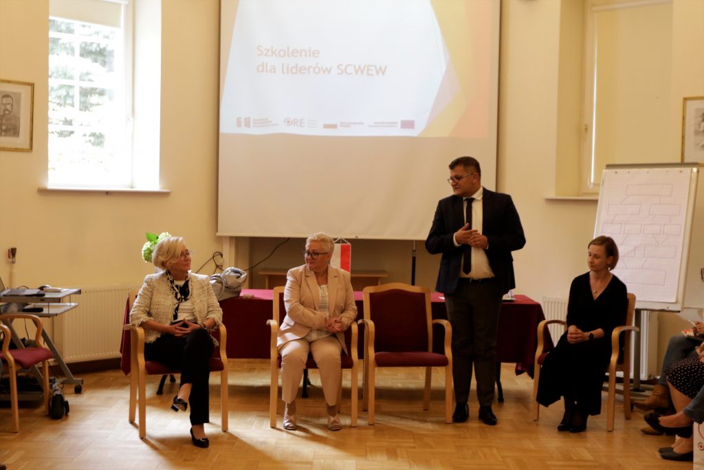 Dyrektor ORE Tomasz Madej (drugi od prawej) wygłasza przemówienie powitalne na spotkaniu liderów SCWEW. Od lewej: Sekretarz Stanu MEiN Marzena Machałek, Dyrektor Departamentu Wychowania i Edukacji Włączającej MEiN Joanna Wilewska. Pierwsza od prawej: Iza Lesińska - kierownik projektu Opracowanie modelu funkcjonowania SCWEW