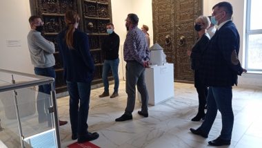 Przedstawiciele Muzeum Początków Państwa Polskiego wspólnie z przedstawicielami Ośrodka Rozwoju Edukacji przed repliką Drzwi Gnieźnieńskich