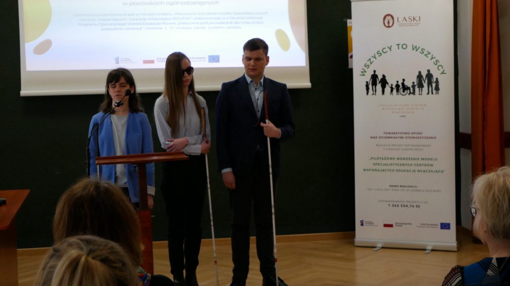 Trzy osoby z Fundacji Prowadnica wygłaszają prelekcję na temat szkoły specjalnej i ogólnodostępnej z perspektywy ucznia niewidomego.