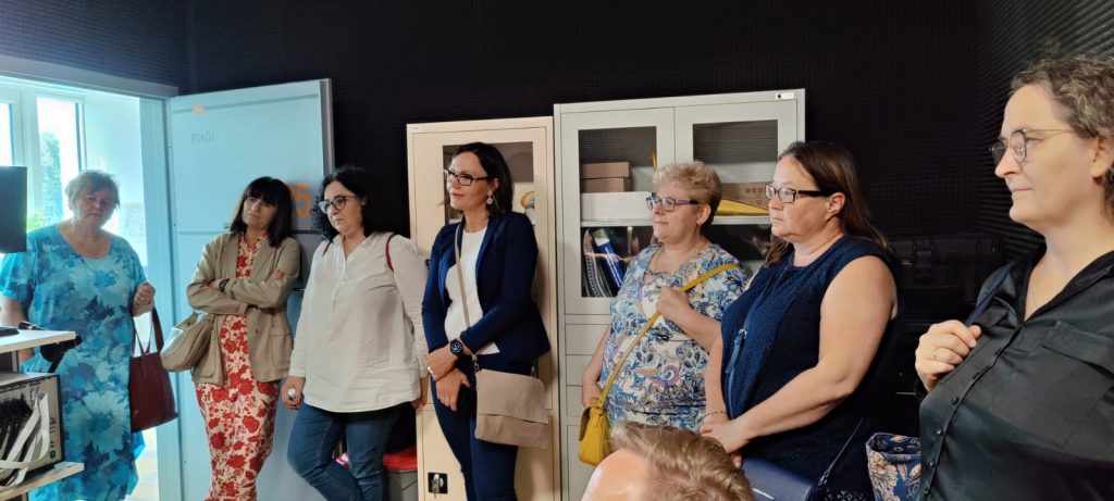 zdjęcie przedstawia siedem osób stojących na tle szaf.