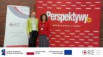 Przedstawicielki zespołu projektu Katarzyna Lidia Kuklińska i Barbara Wałecka stoją na tle stojaka reklamowego z napisem „ORE” i ścianki z napisem „Perspektywy”
