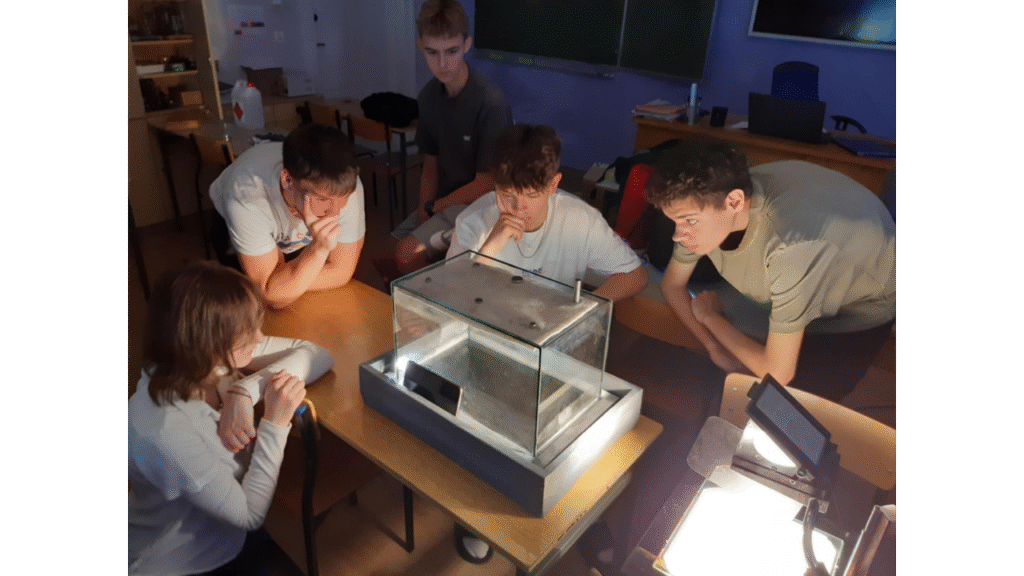 Uczniowie Zespołu Szkół Ponadpodstawowych podczas obserwacji komory mgłowej